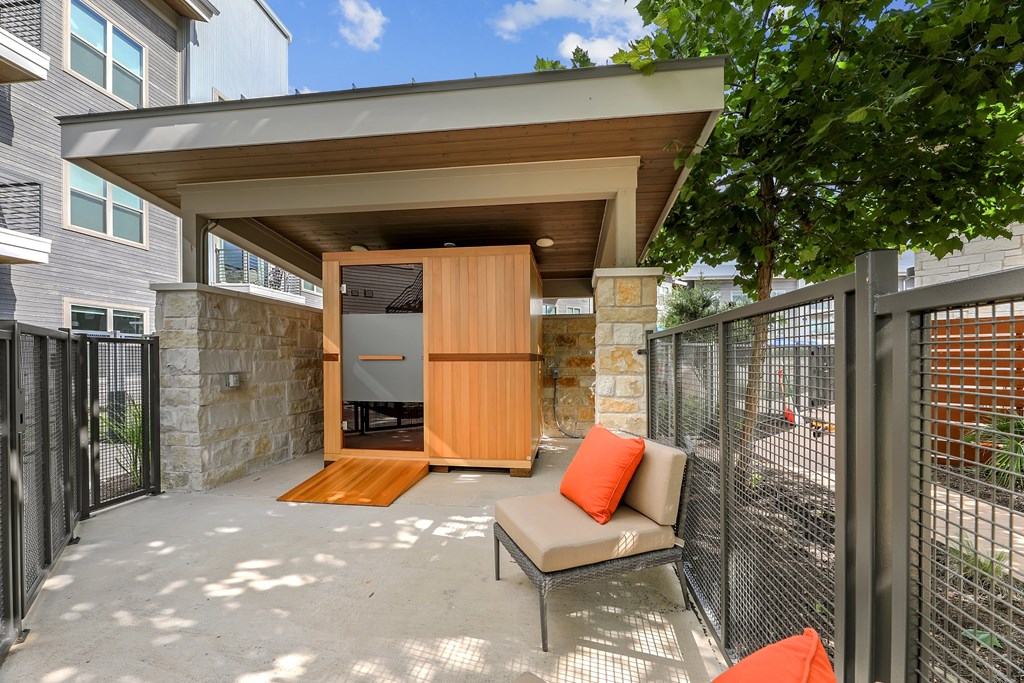 A patio with a couch and a table with a pillow on it.