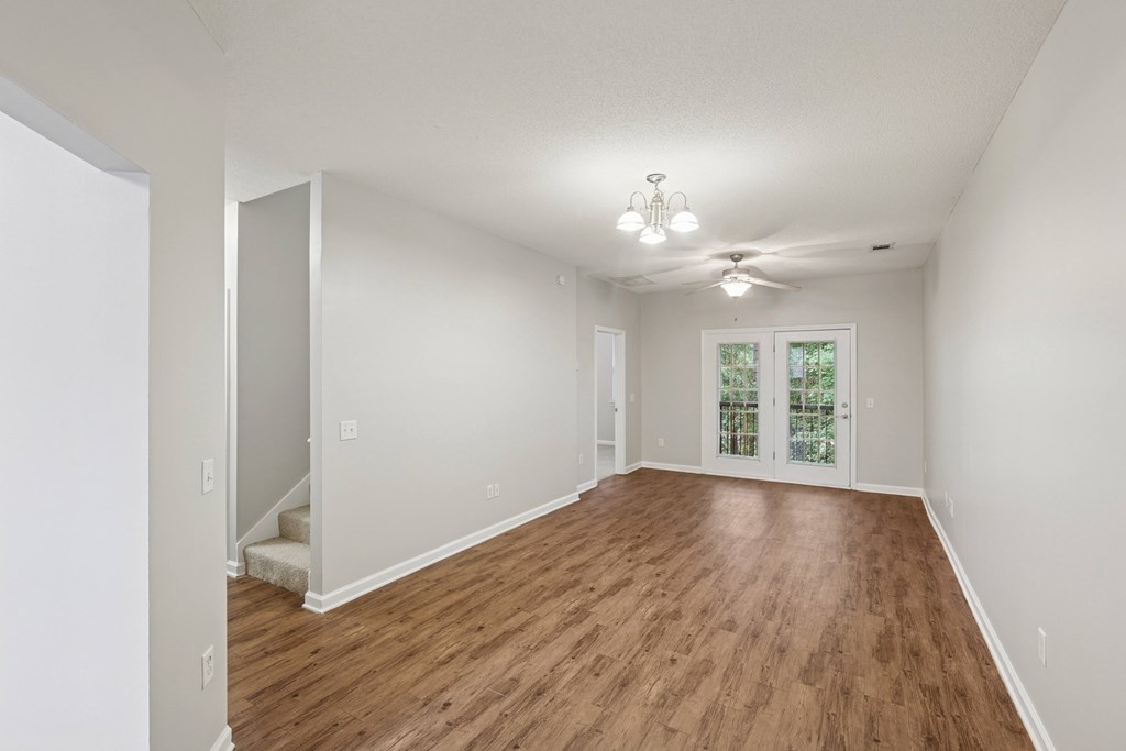 A room with wooden flooring and white walls.