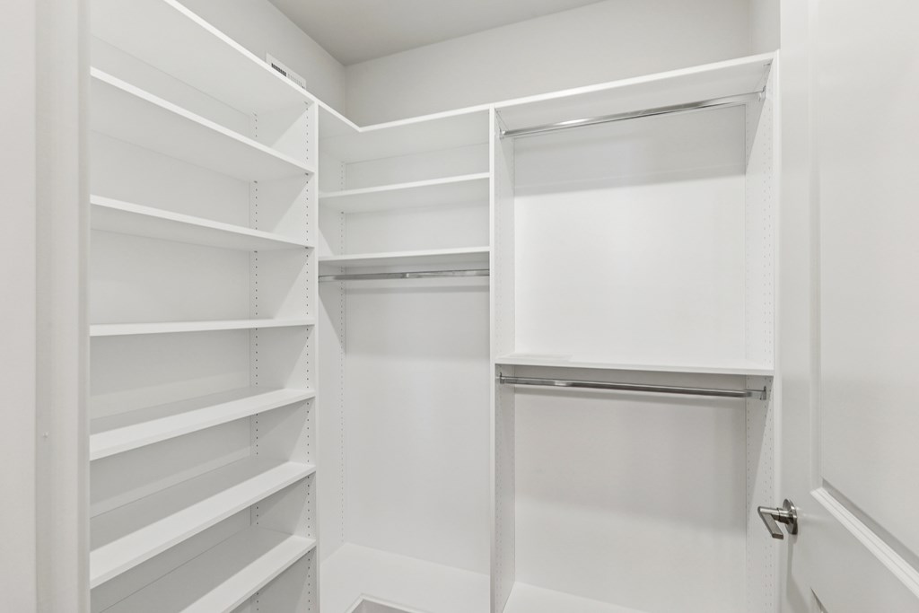 A walk in closet with custom shelves