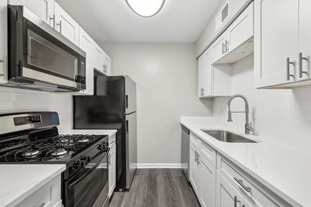 a kitchen with white cabinets and stainless steel appliances