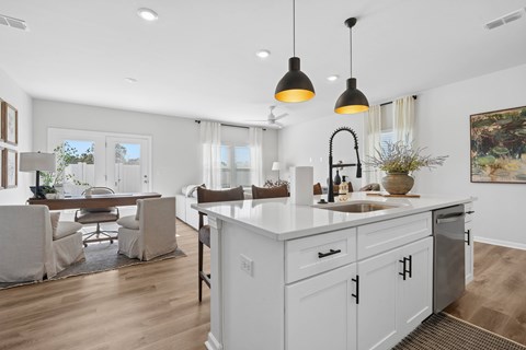 A modern kitchen with white cabinets and a large island.