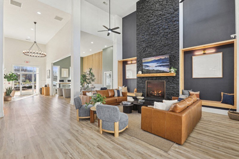 A modern living room with a fireplace and a large painting above it.