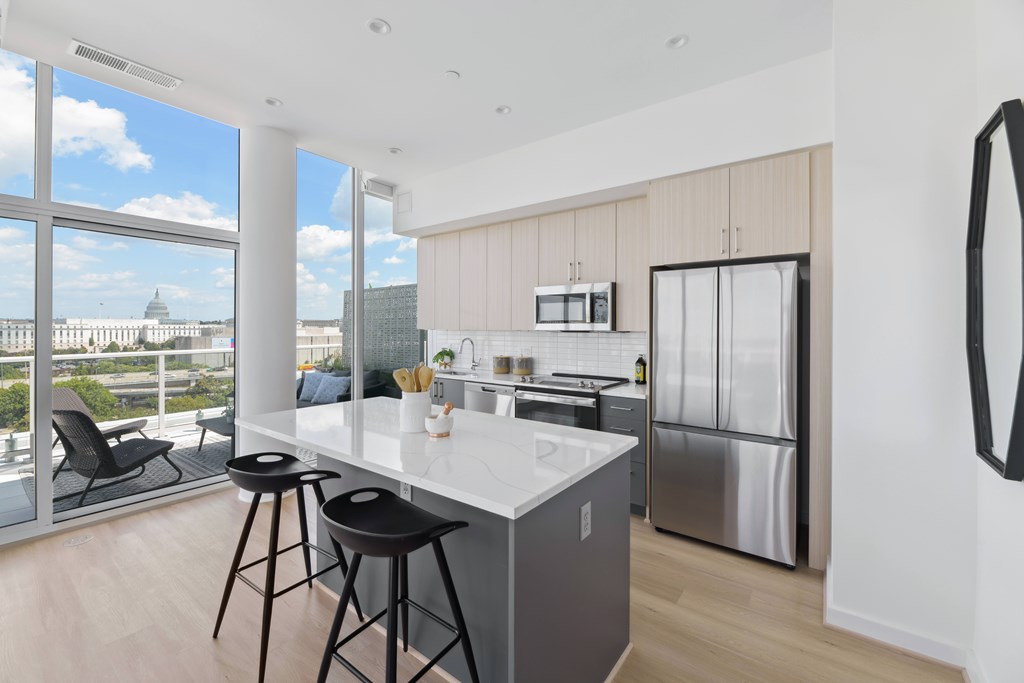A modern kitchen with a bar area and a view of the city.