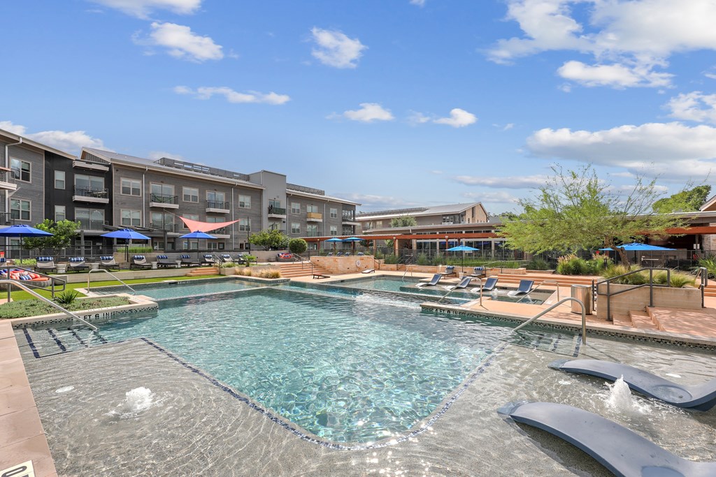 A large swimming pool with a slide in the middle of a residential area.