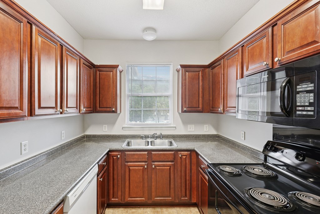 A kitchen with wooden cabinets and a black stove top.