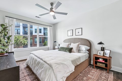 A bedroom with a large bed and a ceiling fan.