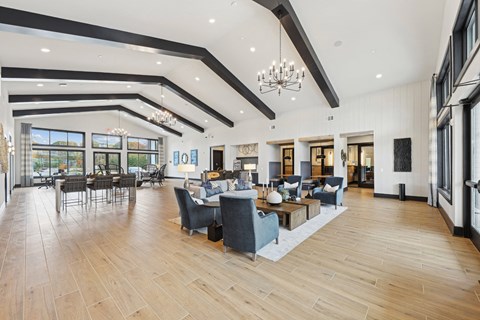 A spacious living room with wooden floors and a variety of seating options.