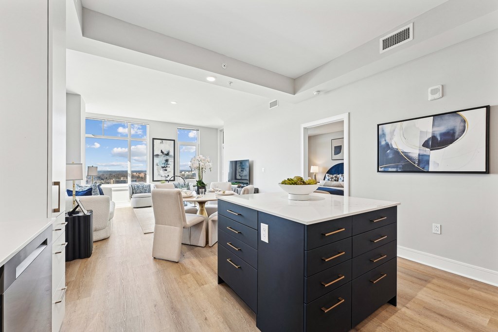 A modern kitchen with a large island and a view of the city.