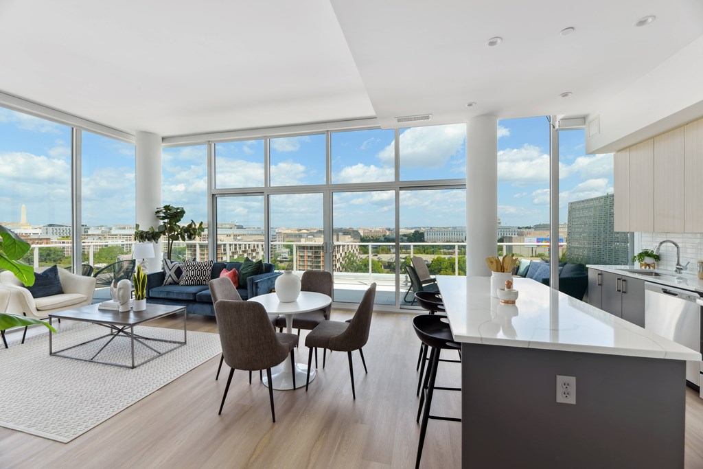 A modern kitchen and living room with a view of the city.