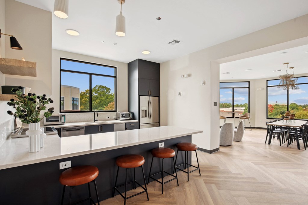 a kitchen with a large island with stools and a table with chairs