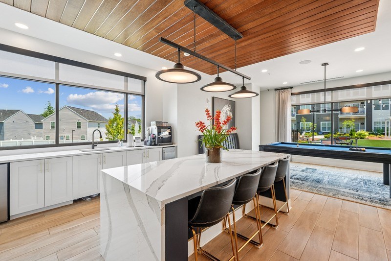 A modern kitchen with a large island and a view of the outdoors.