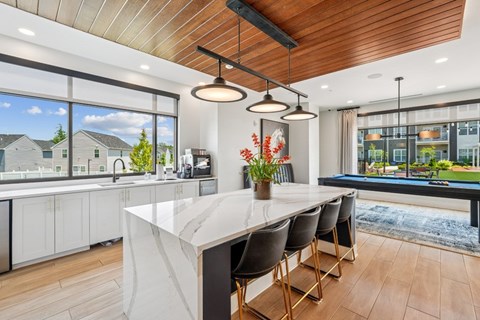 A modern kitchen with a large island and a view of the outdoors.