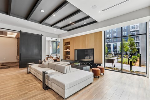 A modern living room with a grey sofa and a wooden floor.