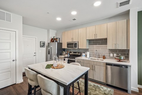 A modern kitchen with a dining table and chairs.