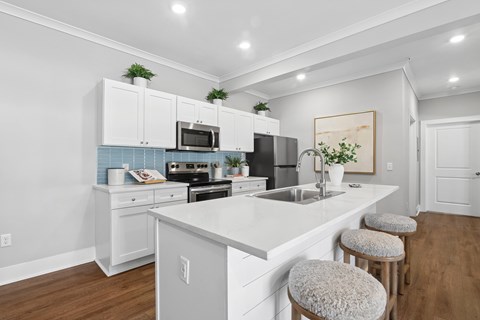 A kitchen with white cabinets and a white countertop.