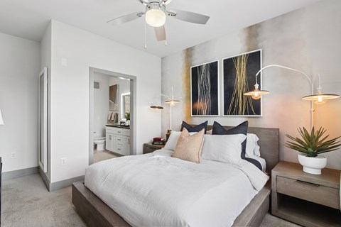 A bedroom with a large bed and a ceiling fan.