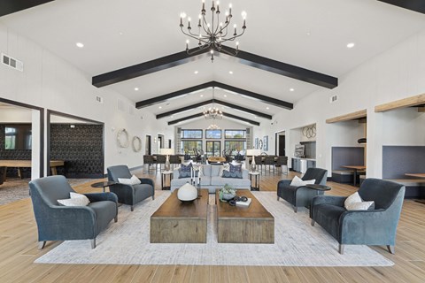 A large, modern living room with a high ceiling and a chandelier.