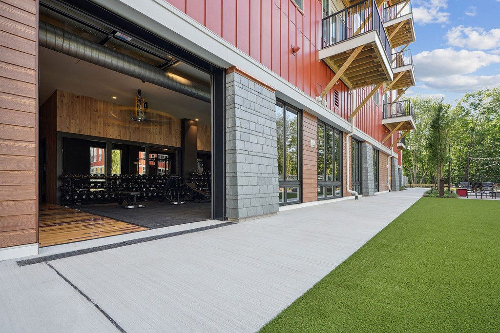 a patio with a lawn and a building with glass doors