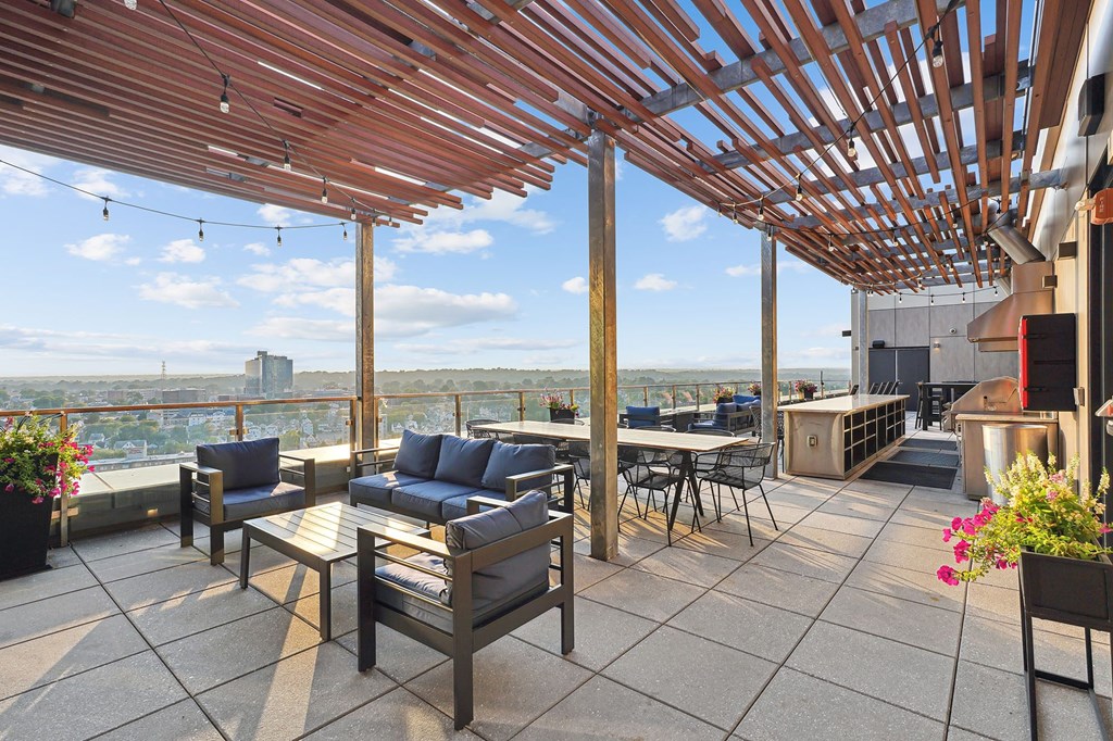 a roof top patio with furniture and a view of the city