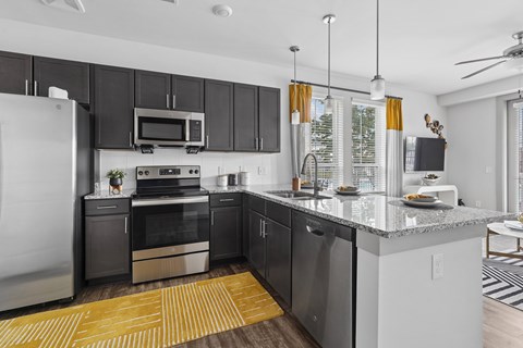 A modern kitchen with a large island and stainless steel appliances.