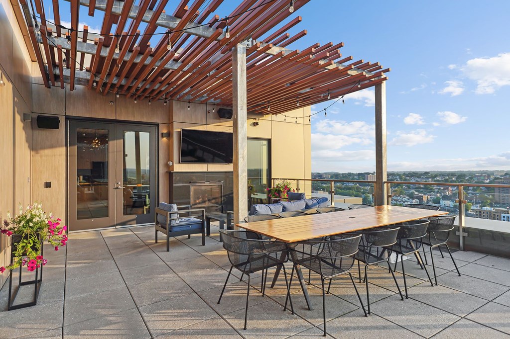 a communal terrace with a table and chairs and a view of the city