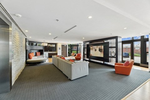 A modern living room with a grey carpet and a white sofa.