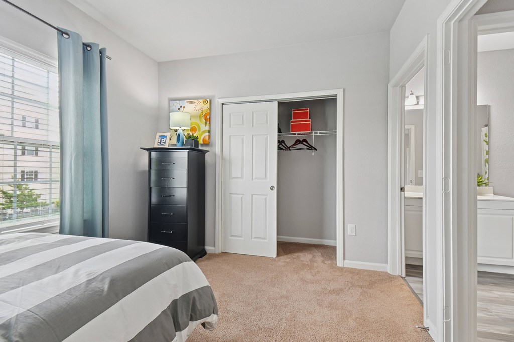 A bedroom with a bed, a dresser, and a wardrobe.