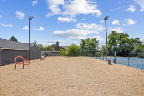 A sandy beach area with a fence and a blue sky.