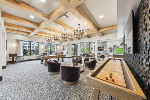 A billiard table is in the middle of a room with a wooden floor and a stone wall.