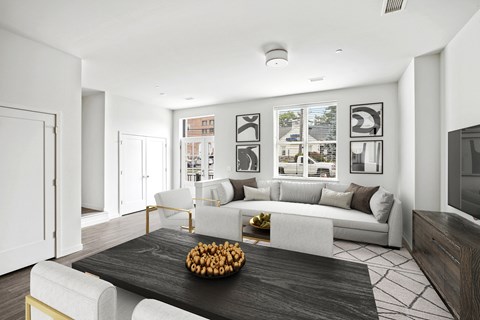 a living room with a large couch and a table with a bowl of fruit on it