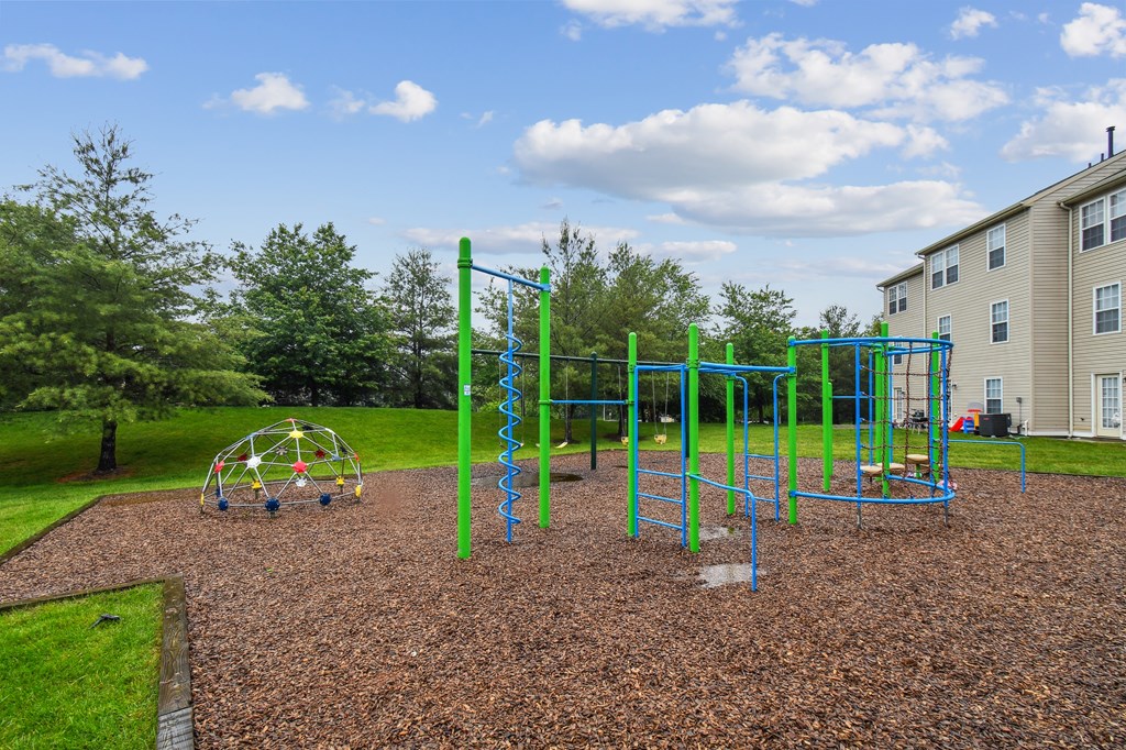 A playground with a green and blue swing set.