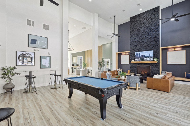 A pool table is in the middle of a room with a fireplace and a TV.