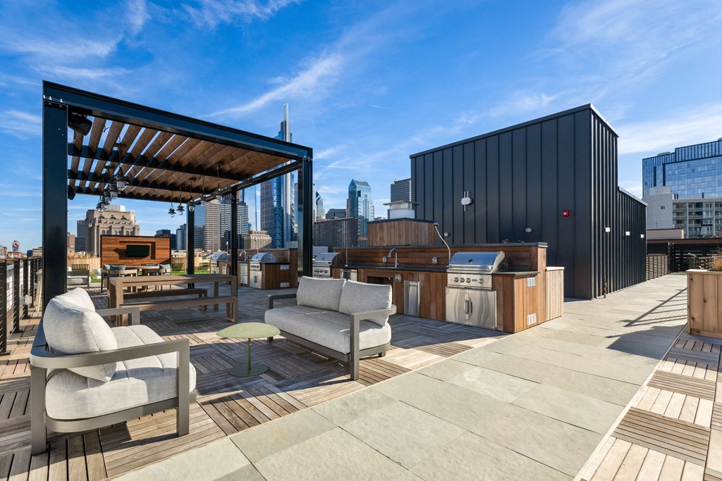a roof terrace with furniture and a view of the city