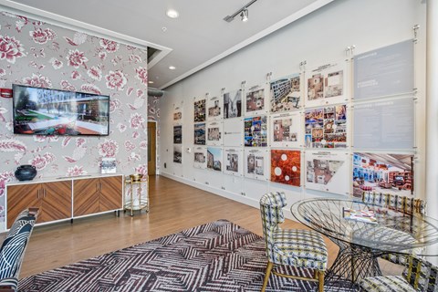 A room with a wall of pictures and a TV on the wall.