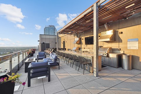 a rooftop bar with a view of the city and a blue sky