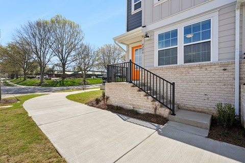 A house with a black railing and a grey wall.