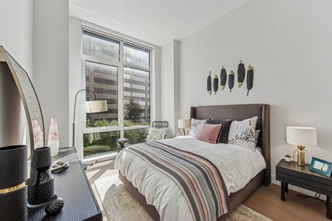 A bedroom with a large bed and a large window.