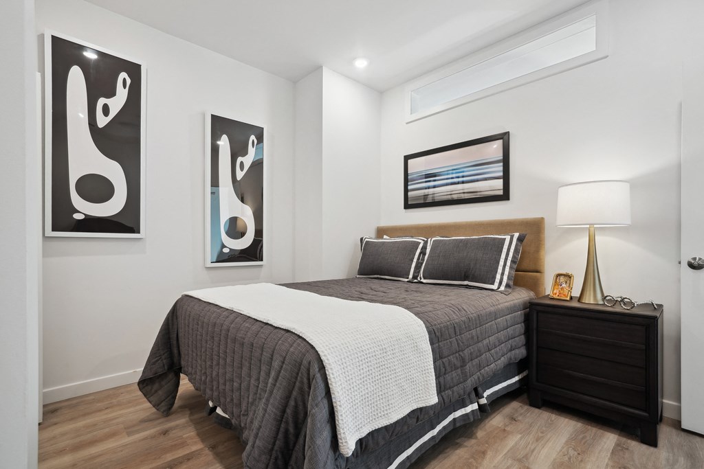 a bedroom with a bed and paintings on the wall