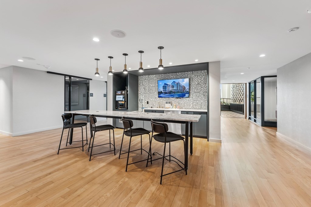 A modern kitchen with a long table and chairs.