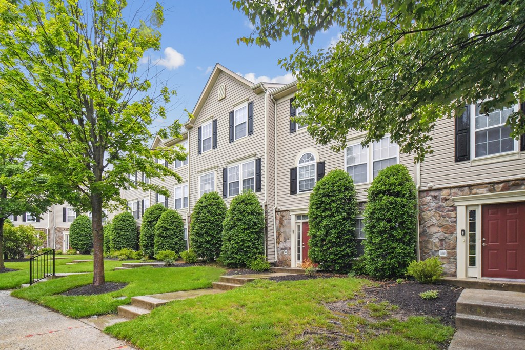 A house with a red door and a tree in front.