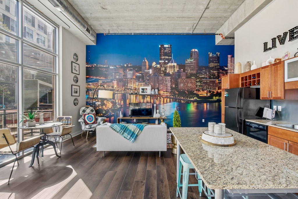 A kitchen with a view of the city at night.