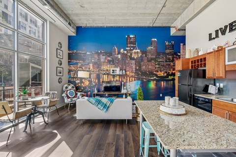 A kitchen with a view of the city at night.