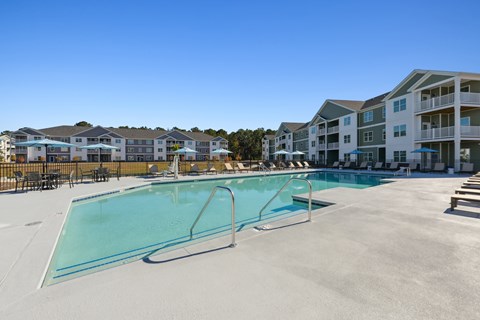 A large swimming pool in front of apartment buildings.