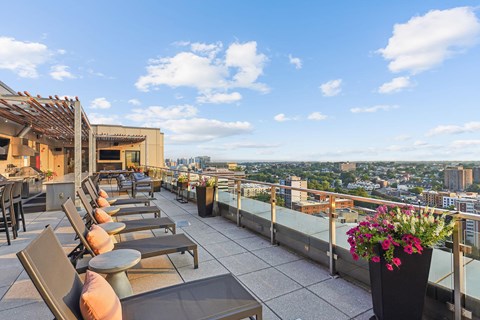 a rooftop terrace with tables and chairs and a view of the city