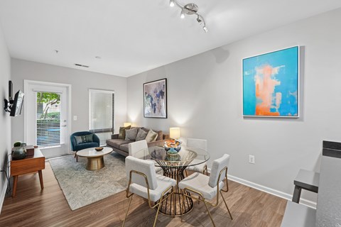 A modern living room with a glass table and white couch.