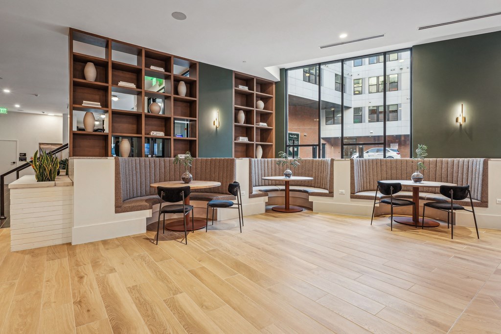 a seating area with tables and chairs and a large window