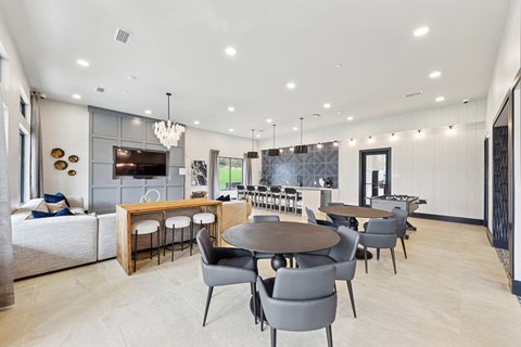 A modern dining room with a wooden table and grey chairs.