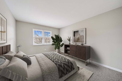 A bedroom with a large bed and a nightstand with a lamp.