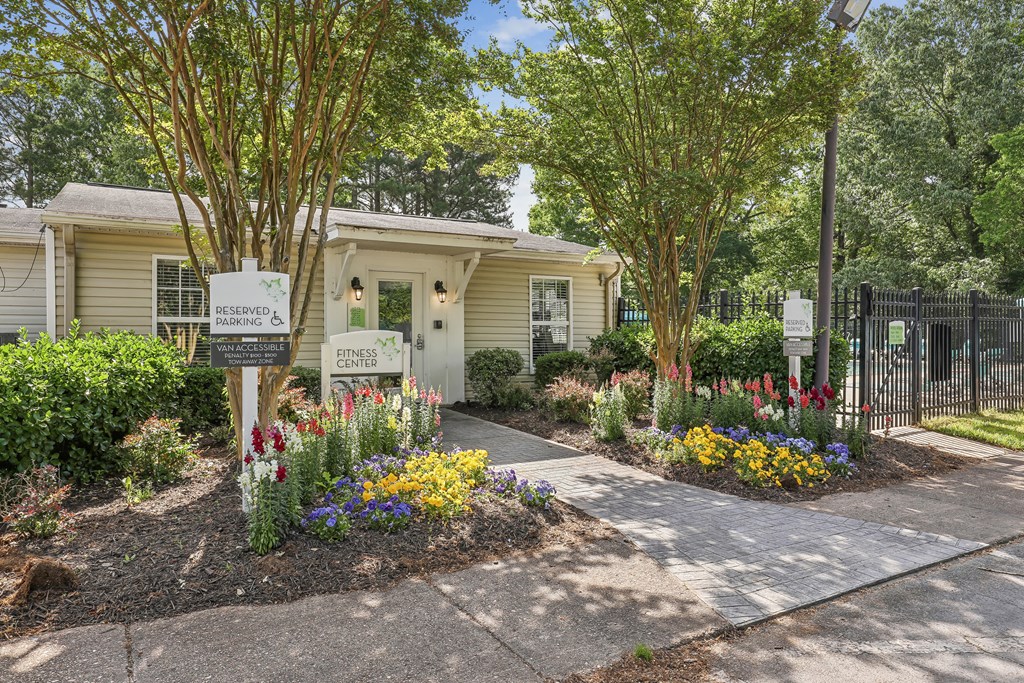 a house with a sidewalk and flowers in front of it