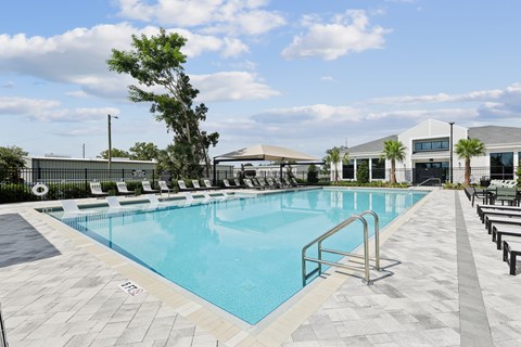 A large swimming pool with a metal ladder and a tiled floor.